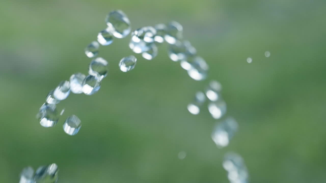 녹색 배경 - 180fps로 느린 동작으로 카메라를 통과하는 순수한 물방울