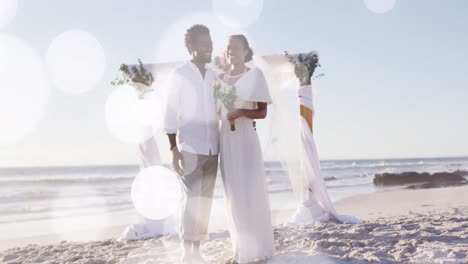 Animation-of-dots-over-happy-african-american-newly-married-couple-on-beach