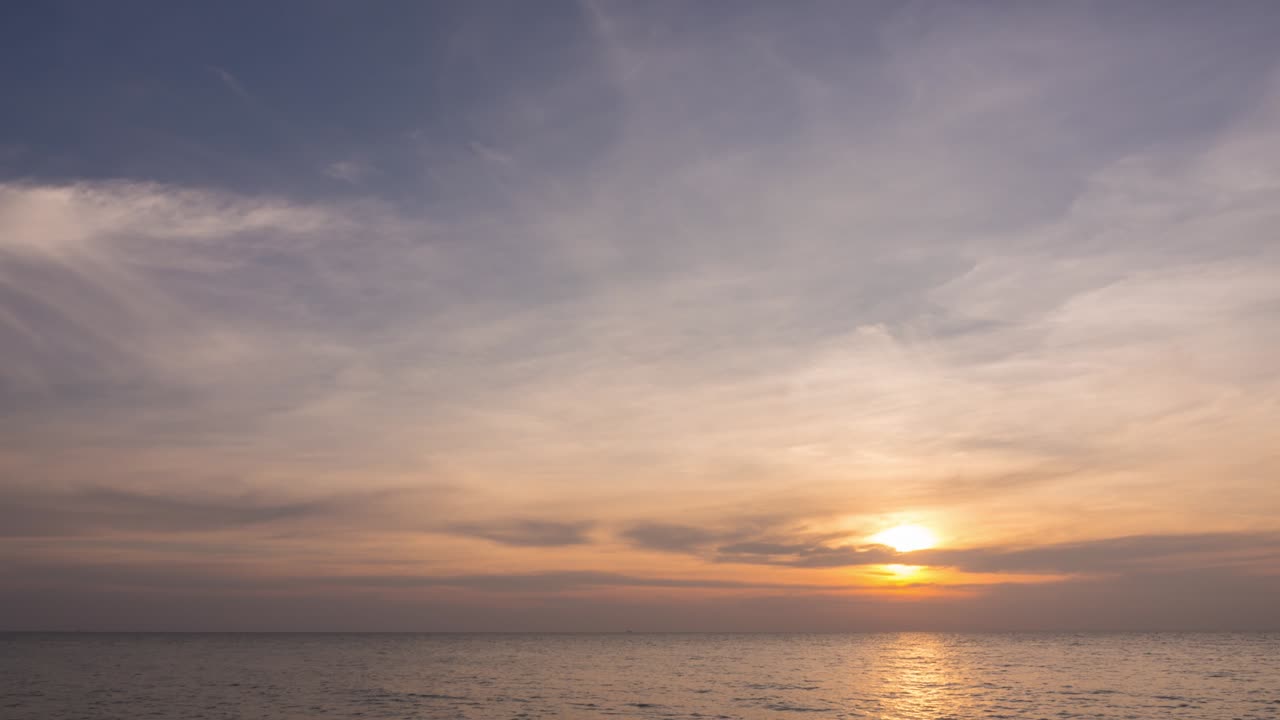 바다 해안에서 놀라운 일몰 파노라마 뷰. 부드러운 실키 시로쿠루스 구름과 함께 아름다운 따뜻한 다채로운 빛. 낮은 수준의 대기에서 회색 구름을 통해 밝은 빛 바다.