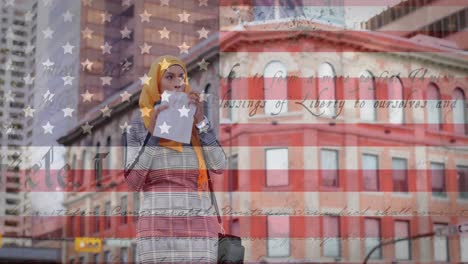 animation of american flag waving over mixed race woman in hijab