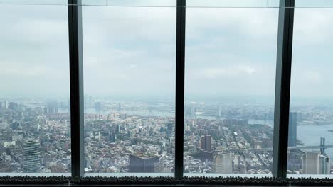 Mirando-Por-La-Ventana-Desde-El-Observatorio-Mundial-De-Nueva-York-Con-Vistas-Al-Sur-De-Manhattan-En-Un-Día-Nublado