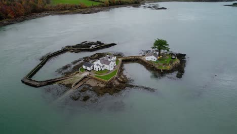 aerial view rising tilt down over ynys gored goch houses on whitebait island welsh flowing menai straits anglesey