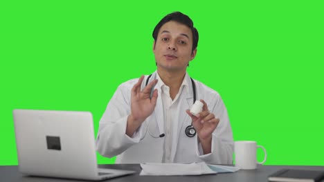 Happy-Indian-doctor-giving-medicine-to-patient-Green-screen