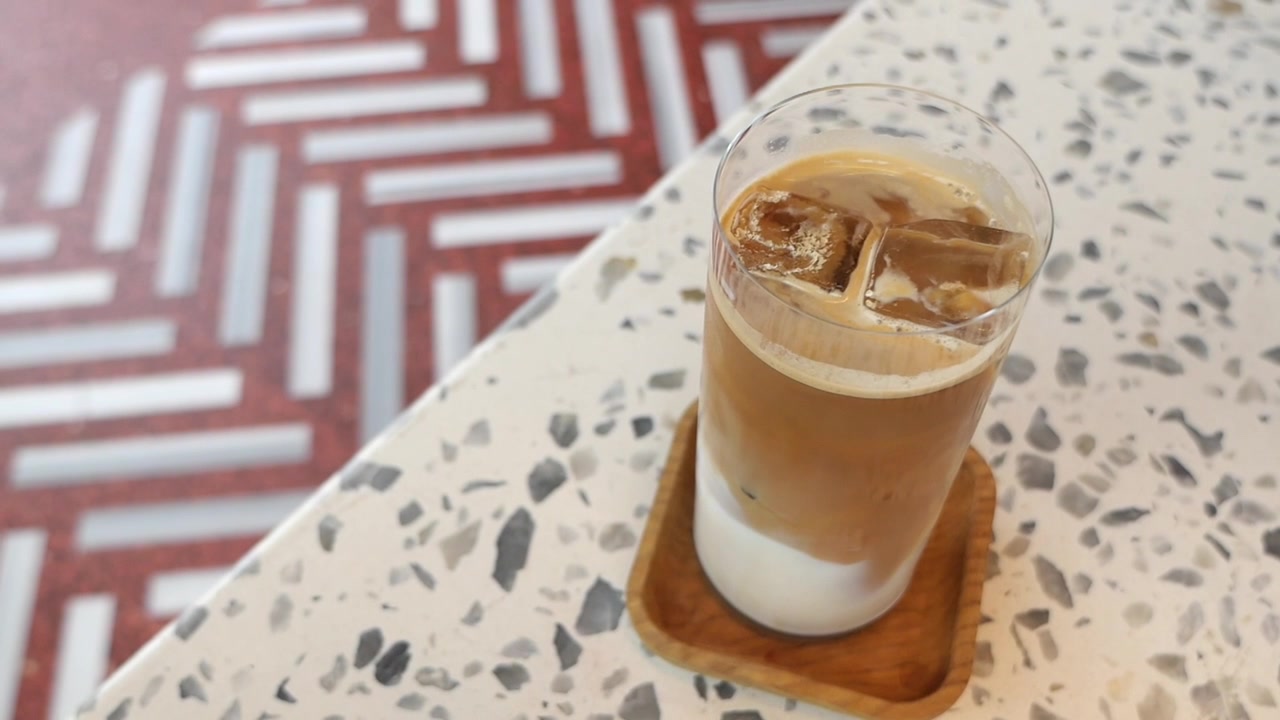 Bicchiere di latte macchiato freddo su un tavolo in terrazzo.
