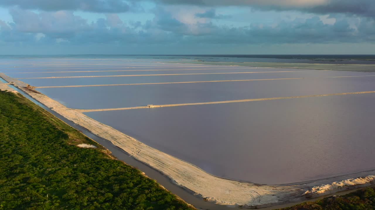 sol reflejándose en el agua en los lagos rosados de las coloradas durante la puesta de sol con nubes azul oscuro