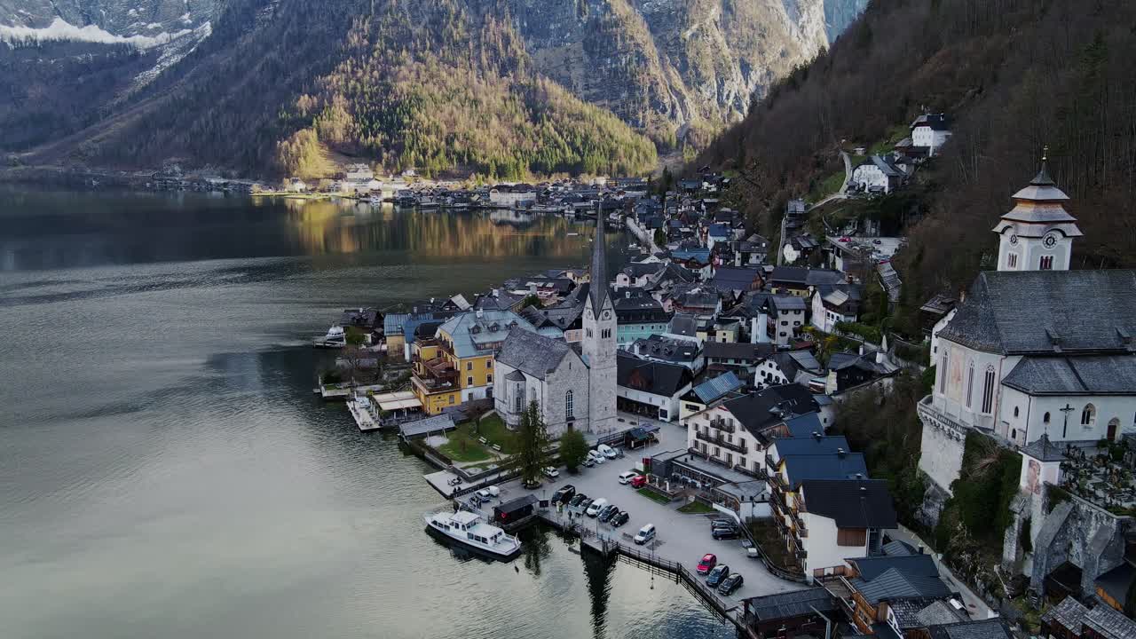 Dramatic sunset view over Hallstatt village, serene lake, snow-capped mountains