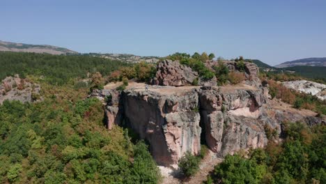 person on sheer rock of harman kaya, ancient thrace rock sanctuary in rhodope mountain, bulgaria