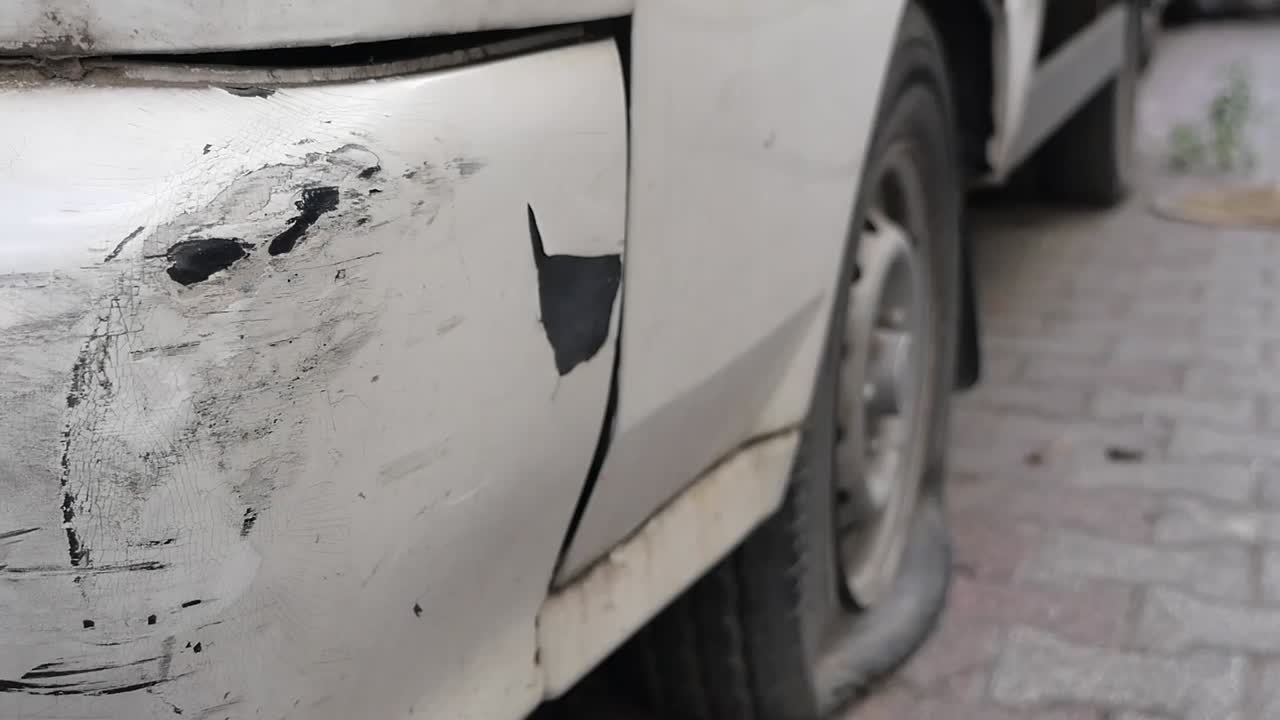 Auto con gravi danni alla carrozzeria e una gomma a terra