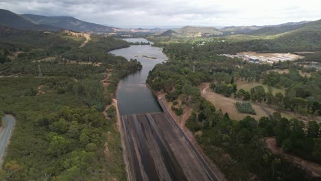 aerial descending over the road and spillway at lake eildon, victoria, australia