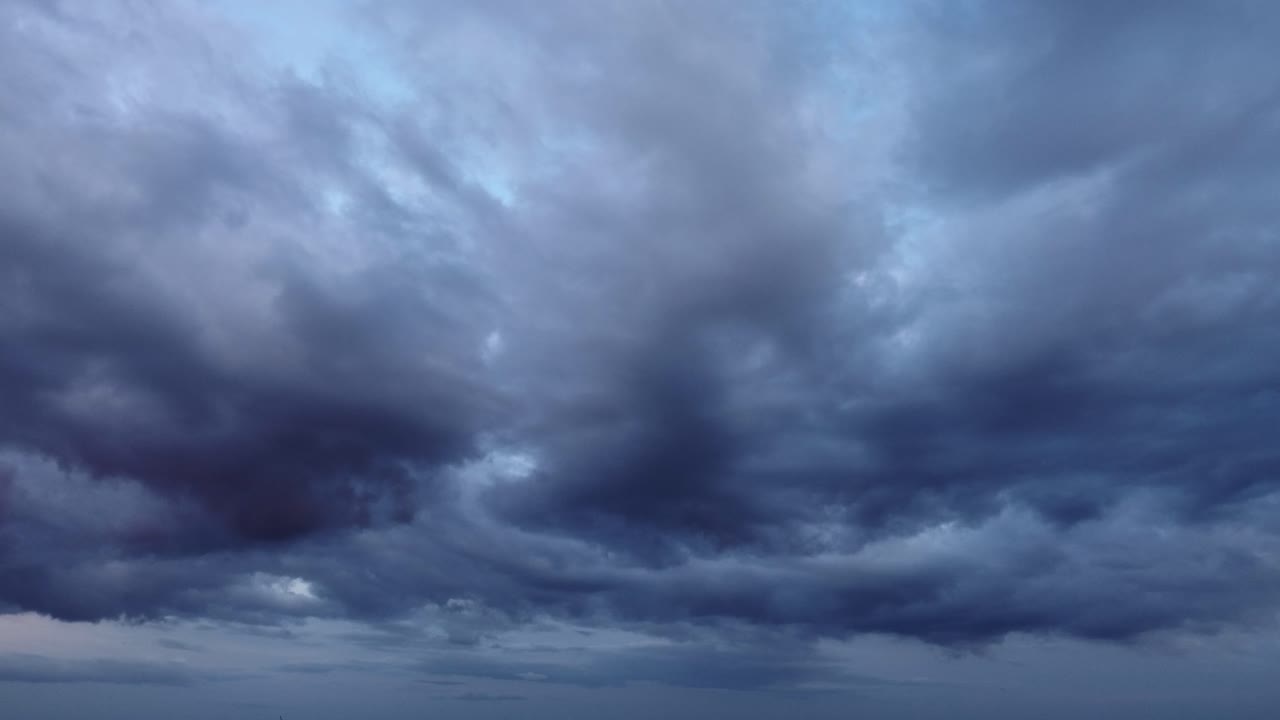 Dark grey stratocumulus storm clouds moving quickly in the sky