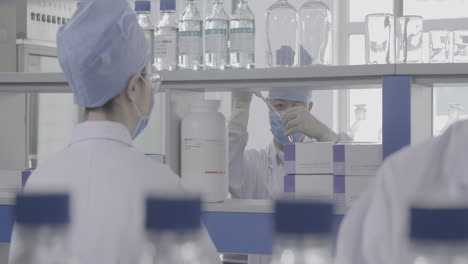 a team of researchers with wear lab coat, gloves work meticulously in a well-illuminated, sterile laboratory, exemplifying teamwork and precision in scientific research