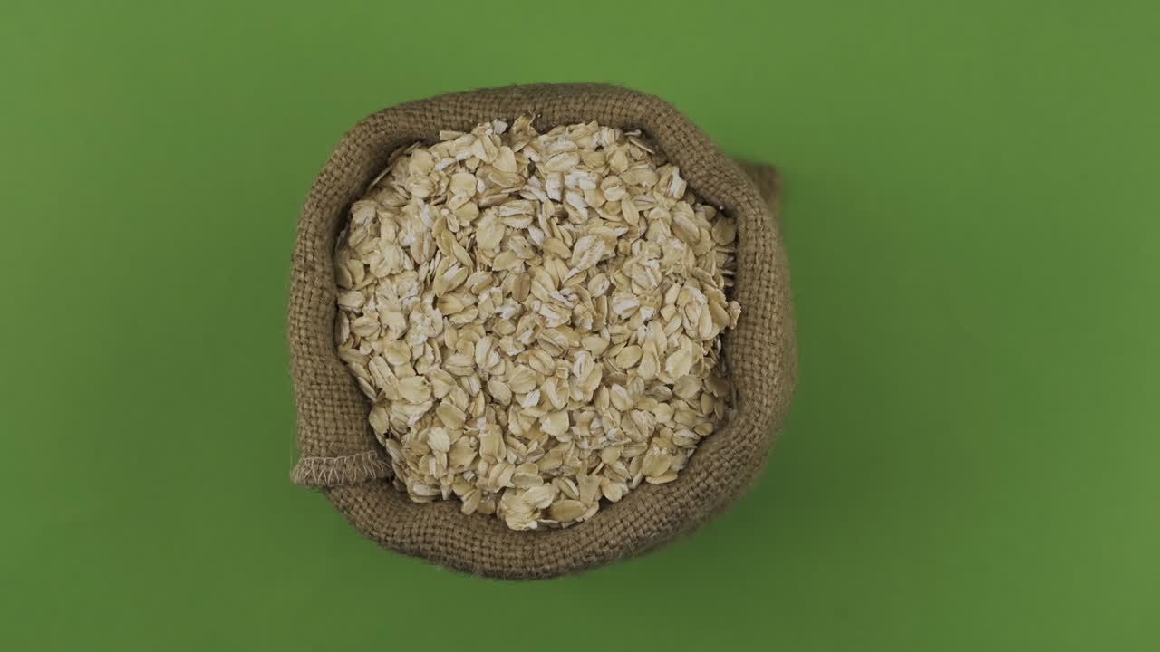 Rotation of a full sack of oat flakes. Top view. Isolated