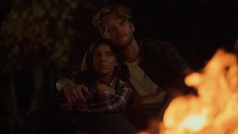 romantic lovers embrace together on night camping journey. couple enjoy bonfire.