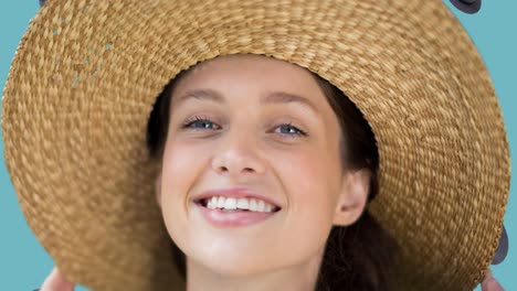 animation of smiling caucasian woman with hat over falling hats on blue background