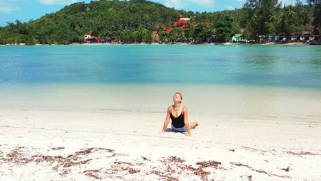 young blonde woman enjoying facing the sun while practicing yoga