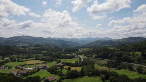 Toma-De-Despegue,-Mientras-Un-Dron-Se-Levanta-Y-Revela-Un-Pequeño-Pueblo-Rodeado-De-Montañas