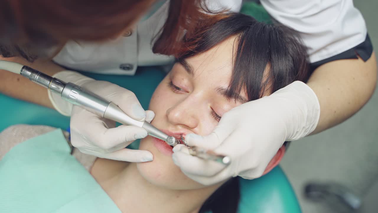 Dentist at work in the office. Woman dentist working at her patients teeth