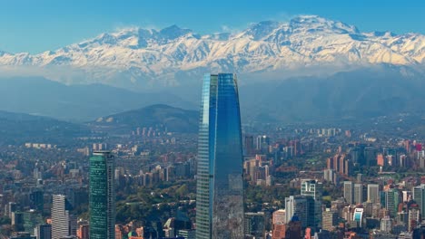 parallax shot of the costanera tower against the andean mountain range in chile