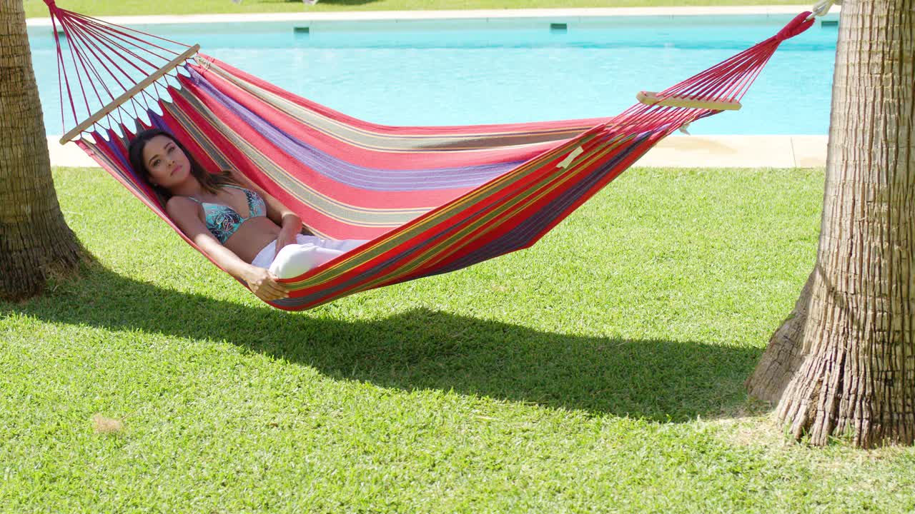 Relaxing young woman in colorful hammock