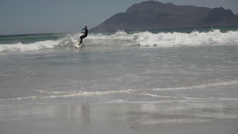 cámara lenta de surfistas a lo largo de la costa en sudáfrica
