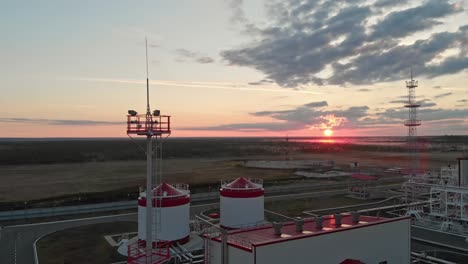 amanecer sobre un campo de petróleo y gas. el avión no tripulado vuela por el área industrial para la extracción de aceite y gas en el campo. el aumento de los precios del petróleo y el gas. la producción de petróleo en rusia o el mundo