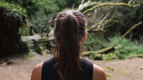 Brown-haired-woman-peacefully-walking-in-forest