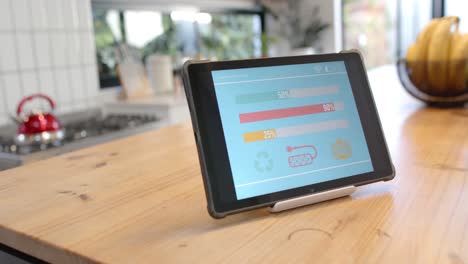 Tablet-with-smart-home-interface-on-wooden-table-in-kitchen,-slow-motion