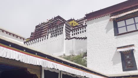 wide sideview angle of potala palace from side showing roofline and stacked architecture with white walls and black trim