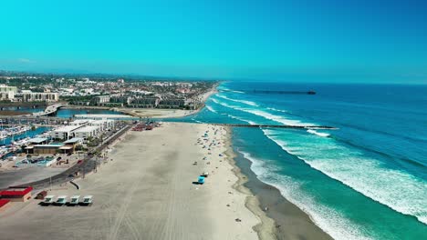 Puerto-En-Oceanside-California-Volando-Hacia-El-Muelle-Sobre-La-Playa,-Arena,-Surf,-Carril-Bici,-Barcos-Y-Puerto-Deportivo,-Parte-1