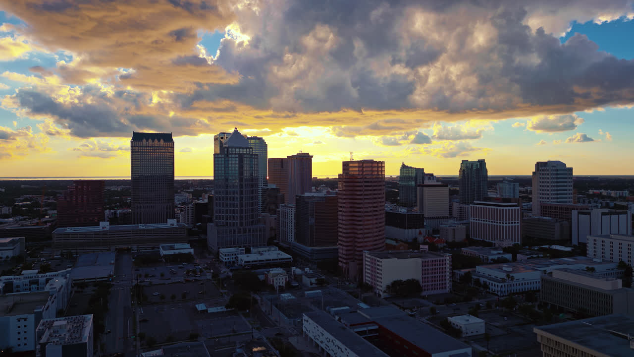 Tampa skyline at dusk dramatic clouds glowing in the sky from the warm setting sun and the warm light reflects on the tall buildings