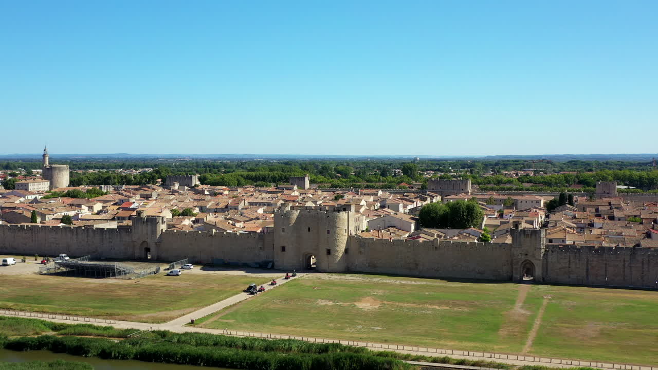 Die historische Stadt Aigues-Mortes in der Camargue, Frankreich, an einem sonnigen Sommertag, gelegen neben einem rosa Salzsee