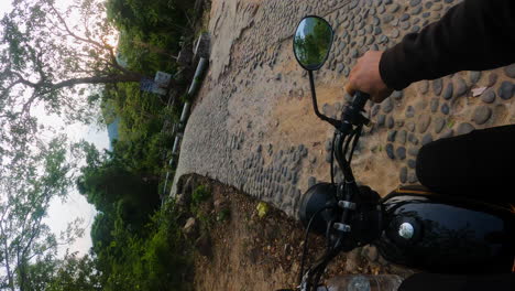 pov vertical video, person riding motorcycle exploring rural tropical countryside in southeast asia