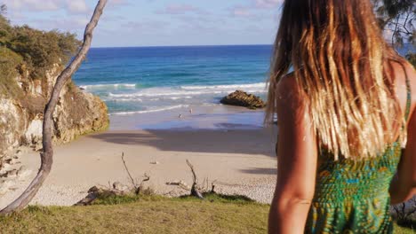 attractive woman walk at headland park then turned around and pose like a model - seascape from north gorge walk and south gorge beach in qld, australia