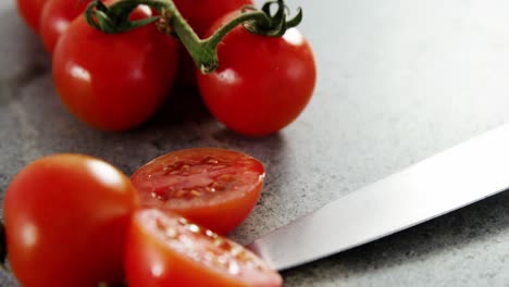 Tomates-Cherry-Y-Cuchillo-De-Cocina-Sobre-Hormigón