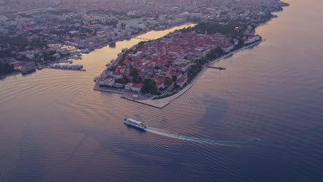 Ferry-boat-arriving-at-dock-of-Zadar-medieval-city-center-at-sunrise