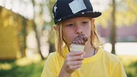 boy eating chocolate ice cream outdoors