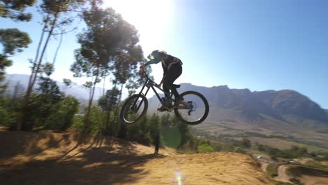 ciclista de montaña extrema haciendo una voltereta hacia atrás durante el darkfest en stellenbosch, sudáfrica