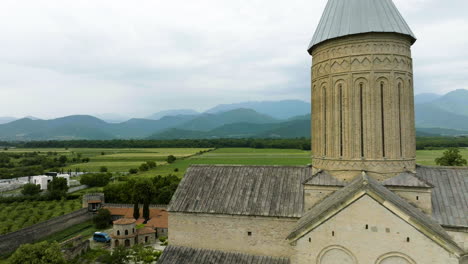 georgian church tower against famous, breathtaking caucasus mountains range