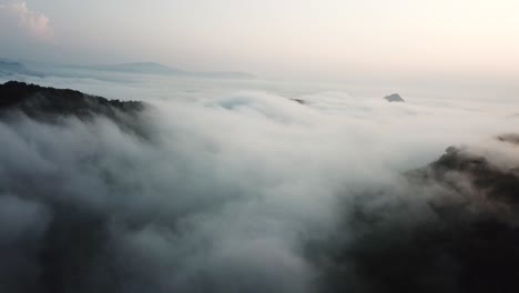 在老<unk>中部的山峰下,山谷上的云在黄昏时,高架空中视图