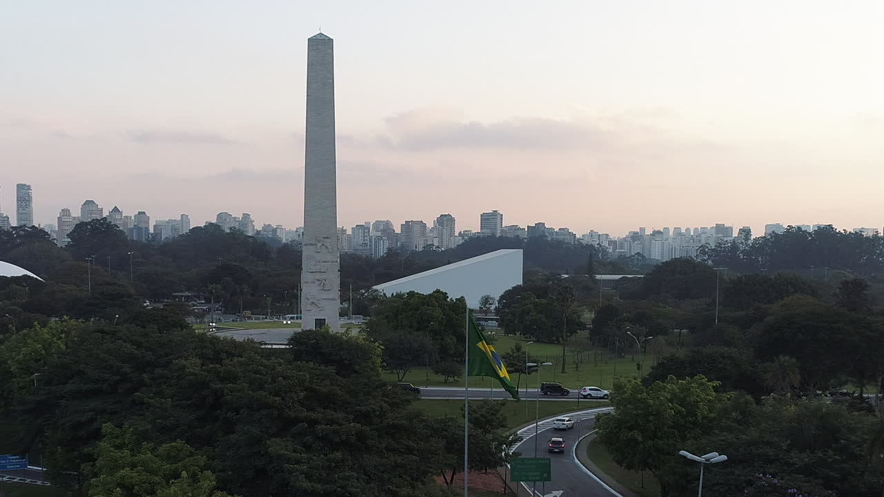Aerial view to brazilian waving flag with the Obelisk monument behind, Sao Paulo, Brazil