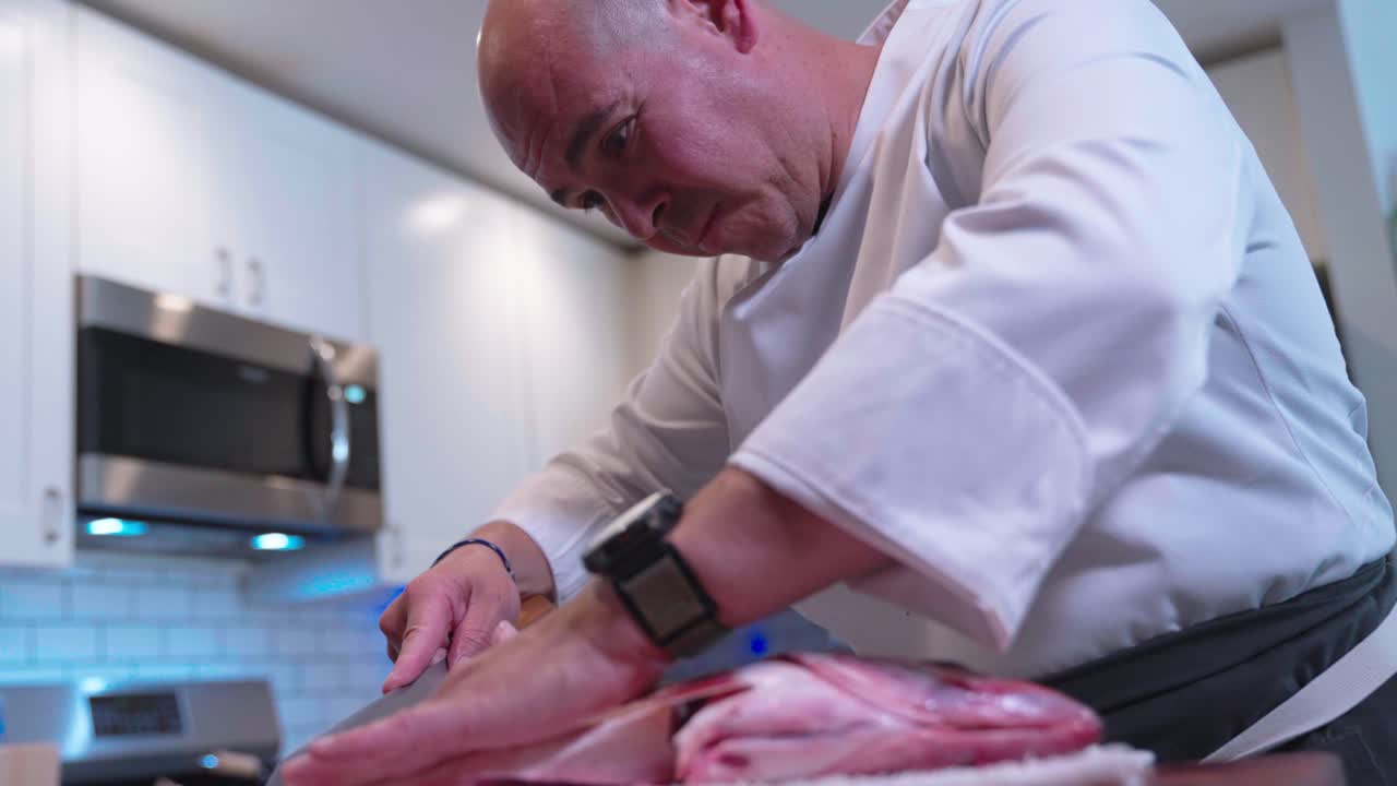 A low-angle static shot captures a chef cutting and prepping fish for sushi, filmed at 120 fps to highlight precision and technique. Perfect for culinary, seafood, and sushi preparation content.
