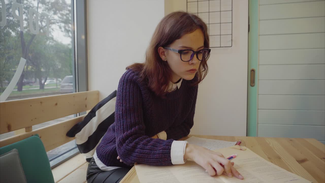 una chica estudiando en un café.