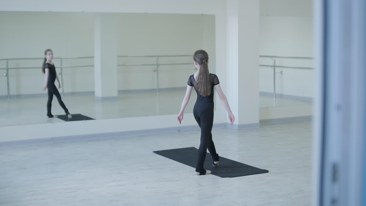 젊은 발레리나 가 스튜디오 에서 춤 을 연습 하고 있다
