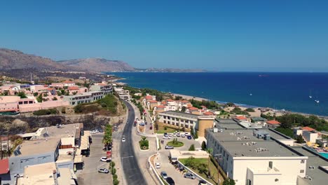 Over-the-road-and-green-Forest-in-Rhodes-with-seaside-in-the-background-in-Greece-during-the-summer-filmed-with-the-drone-in-4K