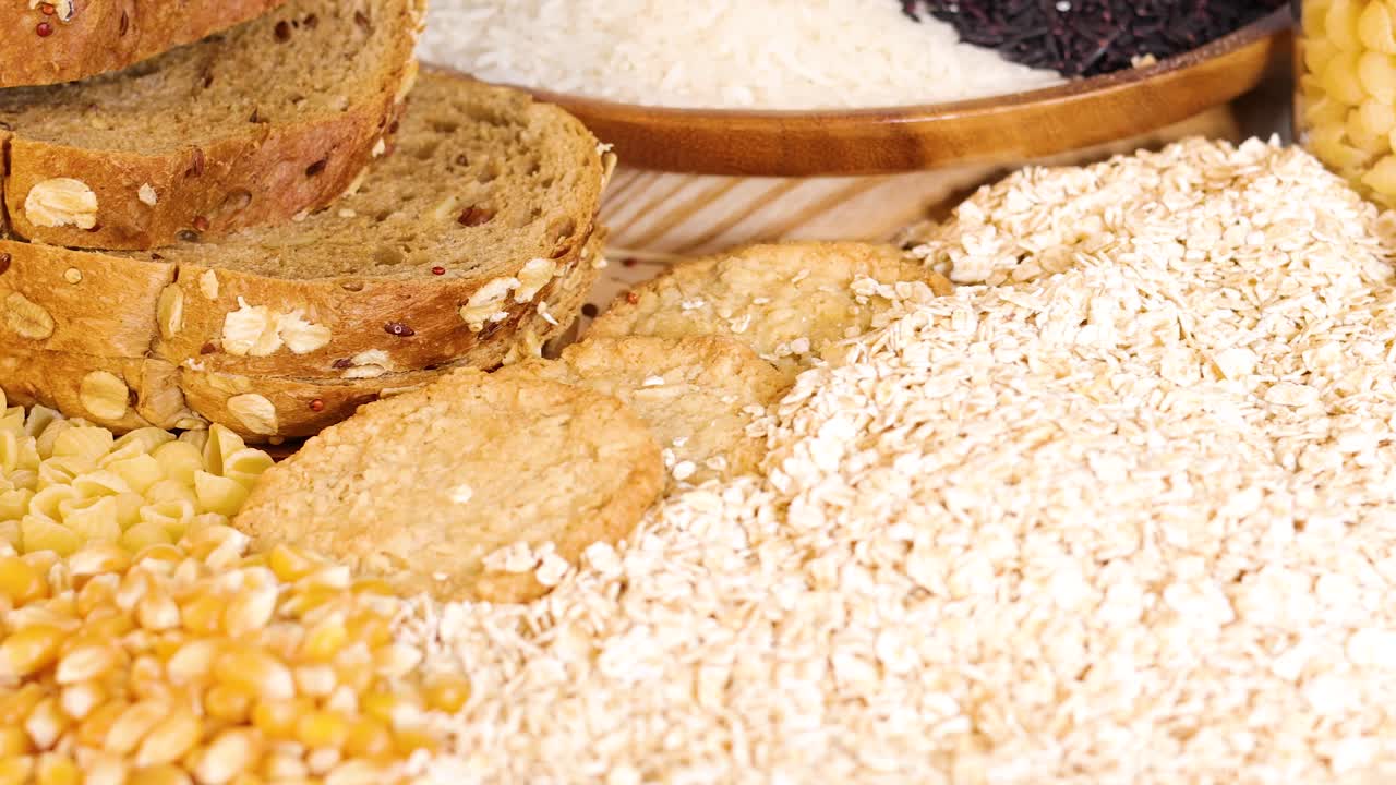 A variety of grains and breads arranged together, showcasing textures and colors under bright lighting