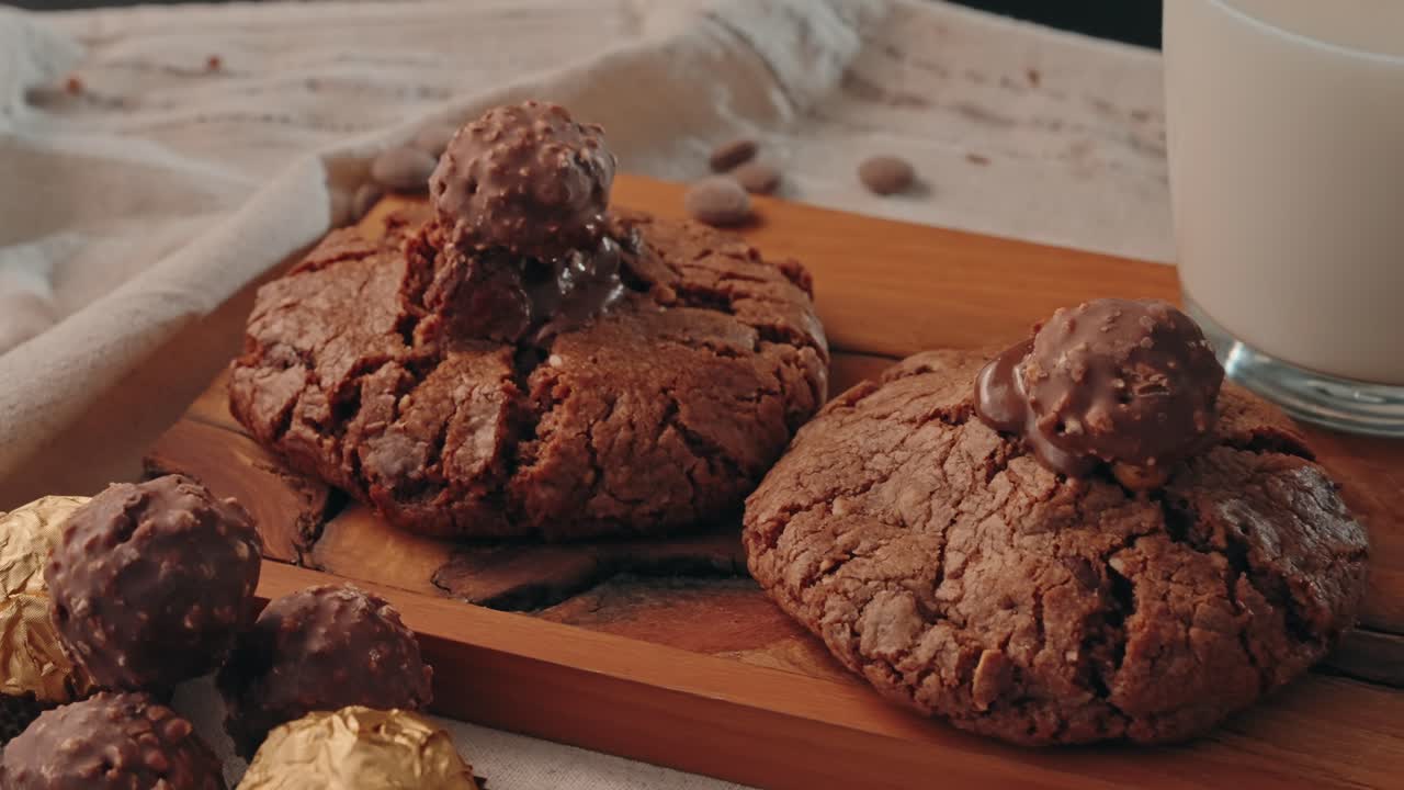 Primo piano di biscotto al cioccolato su tagliere in legno con pallina di zucchero su tavolo interno.