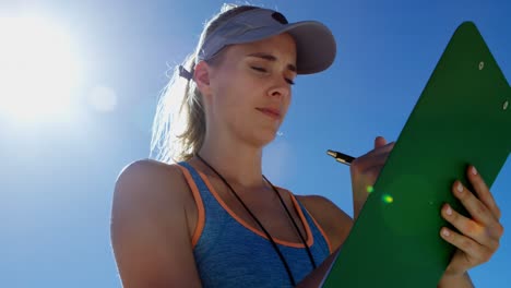 entrenadora de voleibol escribiendo en el clipboard 4k