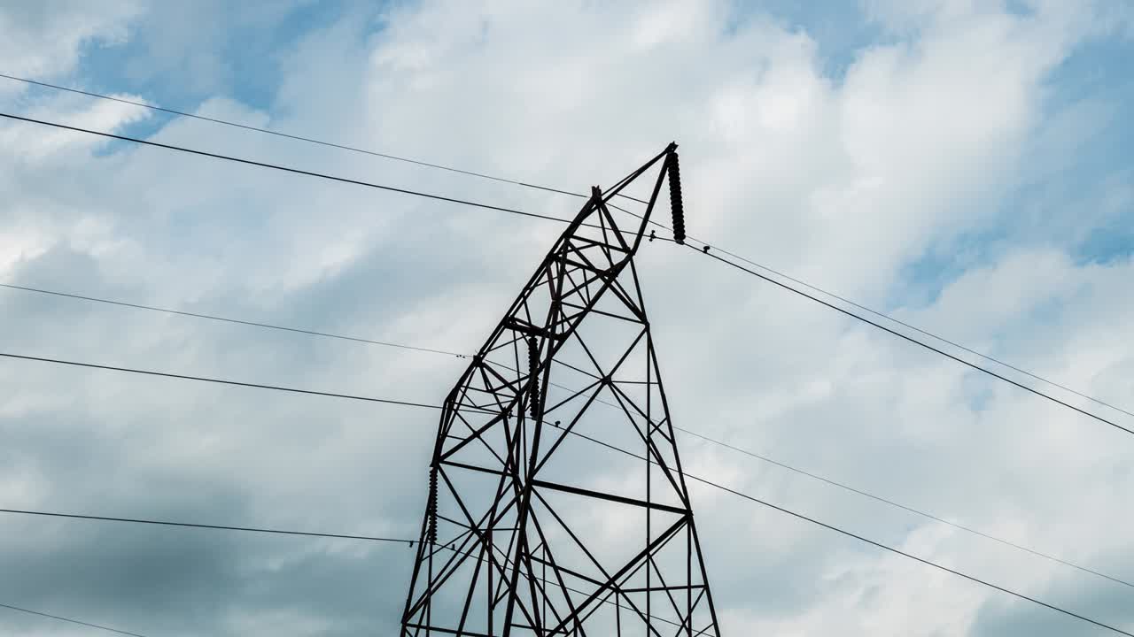 Time Lapse of Electric High Voltage Electricity Tower and power lines under the beautiful sky. Transmission towers. Electricity pylons. Moving through electric high voltage pylon. 4K loop