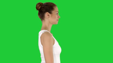 casual young woman walking on a green screen, chroma key