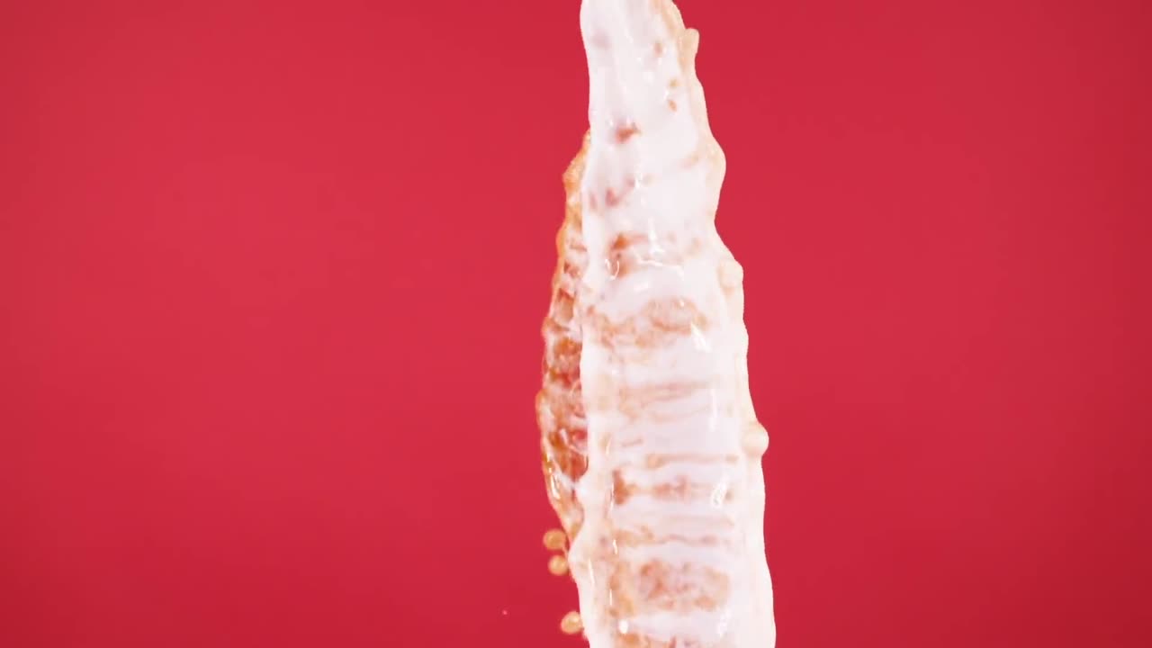 우유와 커피의 폭포가 활기찬 은 배경에서 회전하는 오버레이 비디오는 예술적 유동성과 감각적 쾌락의 개념을 불러일으킨다.